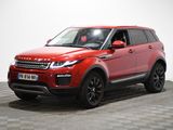 Une Land Rover rouge est garée sur un sol à damier.