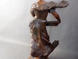 statue of a woman holding a tray of food on top of a wooden base