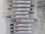 several pens are lined up in a row on a white surface