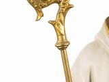 figurine of a saint holding a staff with a white robe and gold trim