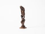 une vieille statue en bois représentant un homme tenant un oiseau, sur fond blanc