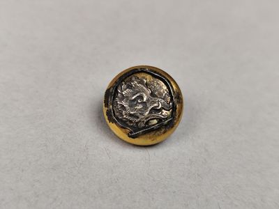 une pièce d'or et d'argent posée sur une surface blanche