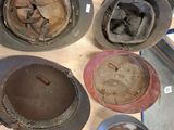 a lot of old helmets that are sitting on a table