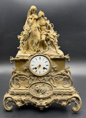 a gold clock with a statue on top of it