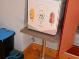 a small refrigerator sitting on a table in the corner of a room