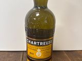 une bouteille de whisky à la Chartreuse posée sur une table en bois