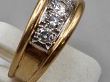 an image of a gold ring with three diamonds on top of it