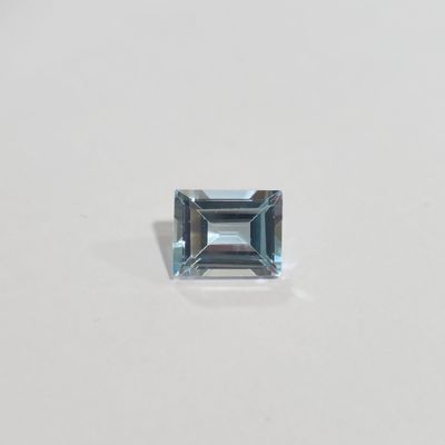an aquamarine blue topazte stone on a white surface