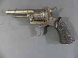 a silver revolver on a table with a silver background