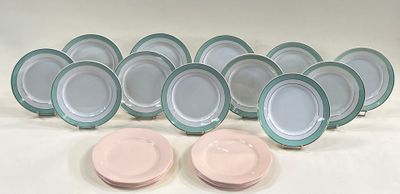 six pink and green plates are lined up on a white surface