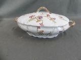 a white bowl with flowers on it sitting on a table