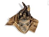 a brown mask with horns on it on a white surface