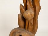 a wooden sculpture that is sitting on a white surface