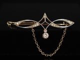 une broche en or et diamants avec une chaîne