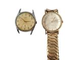 Deux montres différentes sont représentées sur une surface blanche, sur fond blanc.