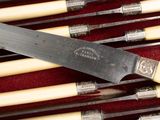 a knife in a case with a lot of chopsticks in it