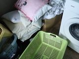 un panier à linge et une machine à laver dans une petite pièce