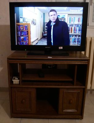 un téléviseur à écran plat posé sur un centre de divertissement en bois