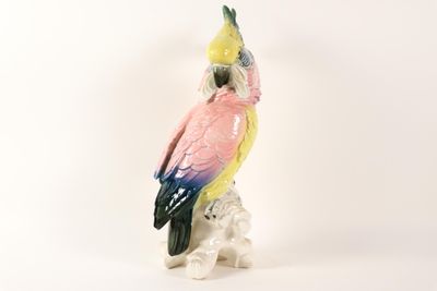 a figurine of a parrot sitting on top of a rock