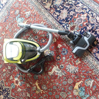 un aspirateur posé sur un tapis, par terre