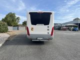 the back end of a white bus parked in a parking lot