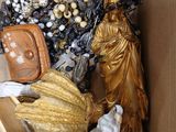 a cardboard box filled with assorted jewelry and a statue