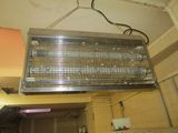a large metal heater hanging from the ceiling in a kitchen