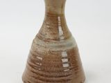 a small brown vase sitting on a white surface