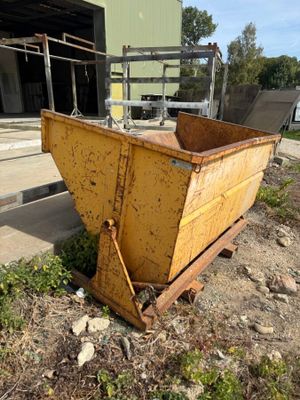 a yellow dumpster sitting on the ground in front of a building