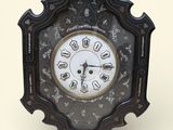 une horloge noire dont le cadran est orné de chiffres romains