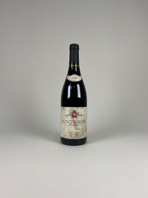 a bottle of red wine sitting on top of a white table