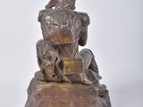 statue of a man sitting on a rock with a dog on his lap