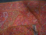 an image of a red and orange shawl with a paisley design