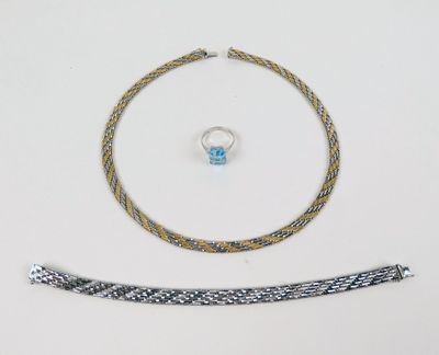 un gros plan sur un collier, un bracelet et une bague posés sur une table