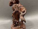 statue of a man riding a horse with a shield on his back