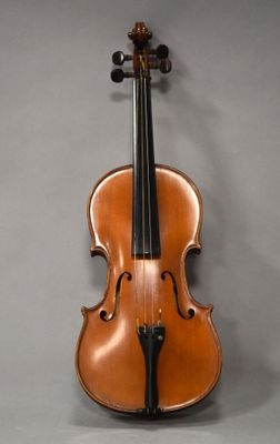 un vieux violon posé sur une surface grise