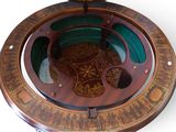 an image of a wooden compass with a green lid
