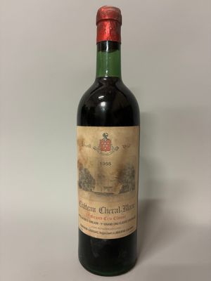 une vieille bouteille de vin posée sur une table blanche