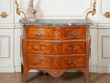 une commode au plateau en marbre, placée au milieu d'une pièce