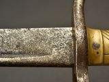 a close up of a sword with a gold decoration on it