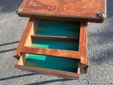 a small wooden table with two drawers on it