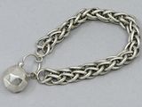 a close up of a silver bracelet with a bell on it