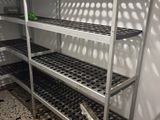a metal shelf in the corner of a kitchen