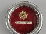 an image of a close up of a small silver object with a red background