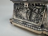a silver box that has a picture of a man and a woman on it