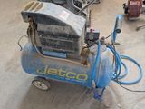 a small air compressor sitting on the floor in a room