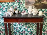 une petite table sur laquelle sont posées des tasses à thé et des théières