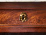a close up of a wooden dresser with a marble top