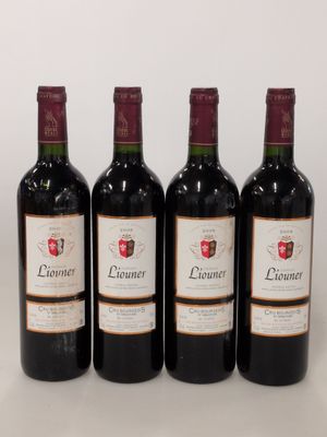four bottles of wine are lined up on a white surface