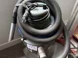 un aspirateur posé sur le sol à côté d'un mur